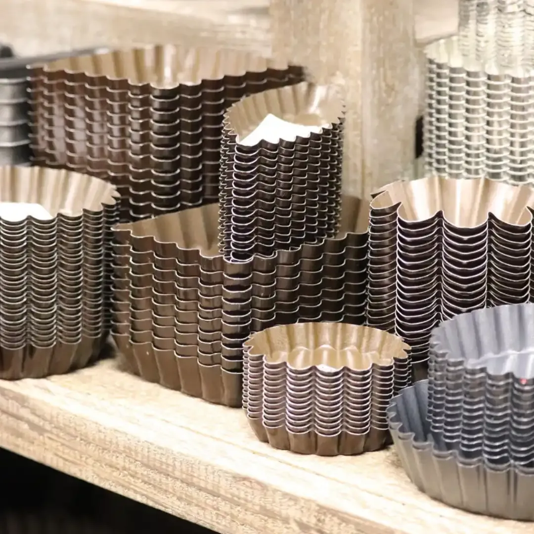 Moules à tartelettes en métal empilés sur une étagère du magasin